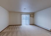 Thumbnail 22 of 49 - the living room of an empty apartment with a sliding glass door. Fargo, ND Lake Crest Apartments