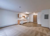 Thumbnail 23 of 49 - an empty living room and kitchen with white walls and a tiled floor. Fargo, ND Lake Crest Apartments