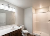Thumbnail 14 of 25 - a bathroom with a large mirror and a toilet and a shower. Fargo, ND 29 West Apartments