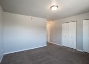 Thumbnail 8 of 25 - a bedroom with carpet and white doors. Fargo, ND 29 West Apartments