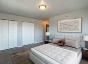 Thumbnail 4 of 25 - a bedroom with a large white bed and white closets. Fargo, ND 29 West Apartments