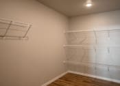 Thumbnail 11 of 25 - an empty closet with three empty shelves in a room with a wood floor. Fargo, ND 29 West Apartments