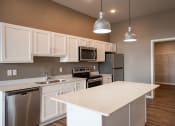 Thumbnail 5 of 25 - a kitchen with white cabinets and stainless steel appliances. Fargo, ND 29 West Apartments