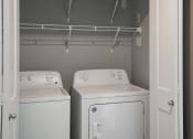 Thumbnail 10 of 25 - an empty laundry room with two washes and a dryer. Fargo, ND 29 West Apartments