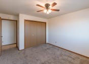 Thumbnail 8 of 13 - a bedroom with a ceiling fan and a closet. Fargo, ND Auburn II Apartments