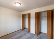 Thumbnail 9 of 13 - Fargo, ND Bayview Apartments. A bedroom with two closets and a carpeted floor