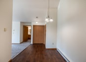 Thumbnail 7 of 13 - Fargo, ND Bayview Apartments. A dining room with a closet, the entry door, and a bathroom in the background.