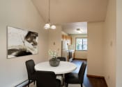 Thumbnail 2 of 13 - Fargo, ND Bayview Apartments. A dining area with a table and chairs and a kitchen in the background