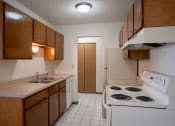 Thumbnail 7 of 15 - a kitchen with a stove and sink and a refrigerator. Fargo, ND Bella Vista Apartments