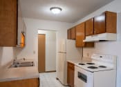 Thumbnail 8 of 15 - an empty kitchen with a stove refrigerator and sink. Fargo, ND Bella Vista Apartments