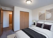 Thumbnail 3 of 15 - a bedroom with a bed and a closet and a door to a bathroom. Fargo, ND Bella Vista Apartments