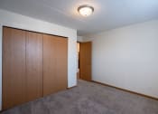Thumbnail 10 of 15 - the living room of an empty apartment with a door to the hallway. Fargo, ND Bella Vista Apartments