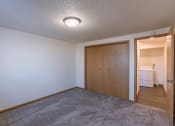 Thumbnail 7 of 9 - a bedroom with a closet and a door to a laundry room. Fargo, ND Berkshire Apartments