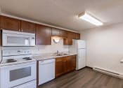 Thumbnail 6 of 9 - a kitchen with white appliances and wooden cabinets and a white refrigerator. Fargo, ND Berkshire Apartments