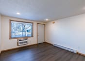 Thumbnail 4 of 9 - an empty living room with a window and a door. Fargo, ND Berkshire Apartments