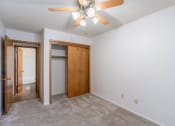 Thumbnail 10 of 25 - an empty bedroom with a ceiling fan and a door to a closet Fargo, ND Betty Ann Apartments
