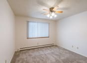 Thumbnail 11 of 25 - a bedroom with carpet and a ceiling fan. Fargo, ND Betty Ann Apartments