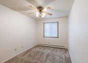 Thumbnail 9 of 25 - a bedroom with a ceiling fan and carpet. Fargo, ND Betty Ann Apartments