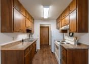 Thumbnail 6 of 25 - a kitchen with white appliances and wooden cabinets. Fargo, ND Betty Ann Apartments