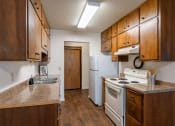 Thumbnail 8 of 25 - a kitchen with white appliances and wooden cabinets. Fargo, ND Betty Ann Apartments
