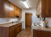 Thumbnail 7 of 25 - a kitchen with a stove and a sink and a refrigerator. Fargo, ND Betty Ann Apartments
