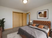 Thumbnail 4 of 16 - a bedroom with a large bed and a potted plant. Fargo, ND Birchwood 2 Apartments