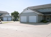 Thumbnail 3 of 4 - a white house with two garage doors and a driveway. Fargo, ND Bluestem Townhomes