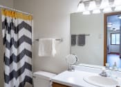 Thumbnail 12 of 26 - a bathroom with a black and white shower curtain. Fargo, ND Briar Pointe Apartments