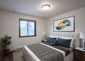 Thumbnail 3 of 26 - a bedroom with a bed and a painting on the wall. Fargo, ND Briar Pointe Apartments