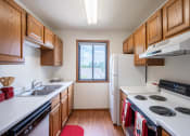 Thumbnail 5 of 26 - a kitchen with white appliances and wooden cabinets and a window. Fargo, ND Briar Pointe Apartments
