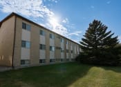 Thumbnail 13 of 13 - the exterior of a brick building with a green lawn and a tree. Fargo, ND Brookfield Apartments