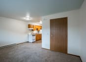 Thumbnail 10 of 33 - an empty living room with a door to a kitchen. Fargo, ND Brownstone Apartments