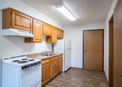 Thumbnail 9 of 33 - a kitchen with white appliances and wooden cabinets and a white refrigerator. Fargo, ND Brownstone Apartments