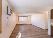 Thumbnail 5 of 17 - Fargo, ND Cambridge Apartments. A living room with hardwood floors and a tv on the wall