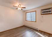Thumbnail 7 of 17 - Fargo, ND Cambridge Apartments. A dining room with a ceiling fan, wood floors, and a window.