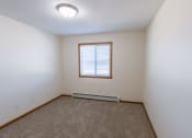 Thumbnail 9 of 17 - Fargo, ND Cambridge Apartments. A bedroom with white walls and a window