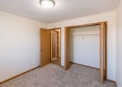 Thumbnail 8 of 17 - Fargo, ND Cambridge Apartments. A bedroom with a closet and a closet door open