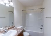Thumbnail 18 of 41 - a bathroom with a tub and a sink and a mirror. Fargo, ND Carlton Place Apartments