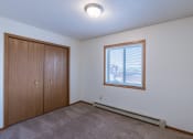 Thumbnail 13 of 41 - an empty living room with a window and a closet. Fargo, ND Carlton Place Apartments