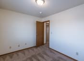 Thumbnail 14 of 41 - a bedroom with carpeted flooring and a door to a closet. Fargo, ND Carlton Place Apartments