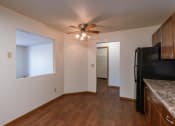 Thumbnail 12 of 41 - a dining room with a kitchen and a ceiling fan. Fargo, ND Carlton Place Apartments