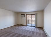 Thumbnail 9 of 41 - an empty living room with a door to a balcony. Fargo, ND Carlton Place Apartments