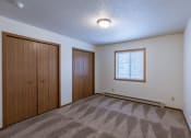 Thumbnail 15 of 41 - a bedroom with a door to a closet and a window. Fargo, ND Carlton Place Apartments