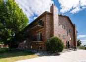 Thumbnail 1 of 13 - Fargo, ND Cedars 2 Apartments. a red brick building with a stone chimney and a tree in front of it