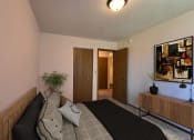 Thumbnail 4 of 10 - a bedroom with a bed and a potted plant. Fargo, ND Chestnut Ridge Apartments