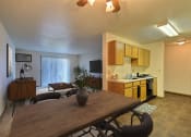 Thumbnail 2 of 10 - an open living room with a dining room table and a kitchen. Fargo, ND Chestnut Ridge Apartments