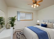 Thumbnail 7 of 42 - a bedroom with a large bed and a ceiling fan. Fargo, ND Country Club Apartments.