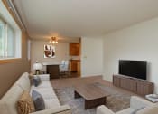 Thumbnail 4 of 42 - a living room with a couch and a television. Fargo, ND Country Club Apartments