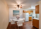 Thumbnail 2 of 44 - a dining area with a table and chairs and a kitchen with a refrigerator. Fargo, ND Country Edge Apartments
