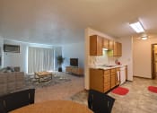 Thumbnail 5 of 44 - an open kitchen and living room with a dining room table. Fargo, ND Country Edge Apartments